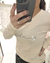 Remera Tokio de mujer color beige con estampa "vida" en letra cursiva negra, usada por una mujer que se está sacando una selfie frente a un espejo
