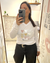 Mujer usando una remera blanca Tokio con estampa de corazones multicolores y texto "You & Me", tomada en un espejo