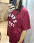 Mujer de perfil usando remerón de algodón bordó con estampa blanca 'Champs Élysées', de corte oversize y manga corta