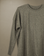 Sweater gris claro de mujer, modelo Over, de manga larga con puños acanalados sobre fondo neutro