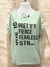 Remera de color verde menta con diseño de texto en negro que dice "SHE IS PRETTY FIERCE FEARLESS STRONG".