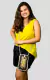 Mulher sorridente usando uma bolsa de crochê elegante, com detalhes em amarelo e marrom, vestindo uma blusa amarela e short preto.