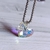 Dije corazón cristal tornasol con argolla (1,5 x 2 cm)