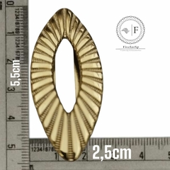 Fivela de metal dourada com dimensões de 5,5 cm x 2,5 cm, exibindo detalhes em relevo.