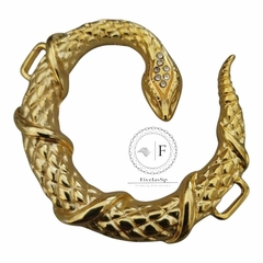 Fivela de metal em formato de serpente com strass na cabeça, medindo 7,5 cm de comprimento e 7,0 cm de largura.