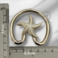 Fivela modelo estrela com extensão em ABS na cor dourada, com medidas de 5,0cm e 5,5cm, sobre fundo neutro.