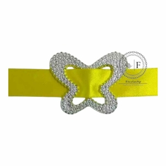 Fivela de plástico modelo borboleta cor prata com passante em fita amarela, ideal para decoração e acessórios.