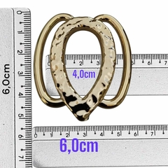 Fivela plástica oval dourada com alça lateral, medindo 6cm de largura e 4cm de altura.