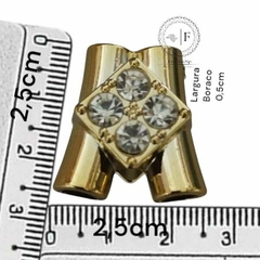 Passante dourado com strass ABS para meia cana medindo aproximadamente 2,5 cm de largura e 0,5 cm de altura, com régua ao lado para referência de tamanho
