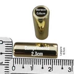 Separador busto biquíni tubular dourado, medindo 2,3 cm de comprimento e 0,7 cm de largura, com orifício de 0,6 cm.