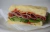 Sandwichitos en pan de focaccia con jamón crudo, rúcula y tomates secos (12 un)