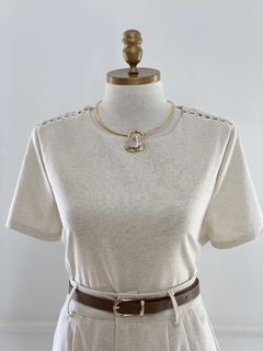 Conjunto Roberta Linho com blusa de manga curta e calça, apresentando detalhes em linho e um colar elegante.