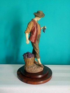 Antiga escultura figurativa representando vendedor de uva em resina italiana - loja online