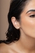 Brinco liso em formato V com banho de ouro 18K, exibido na orelha de uma mulher com cabelo molhado.