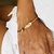 Pulsera rígida dorada laurel y bolita - comprar online