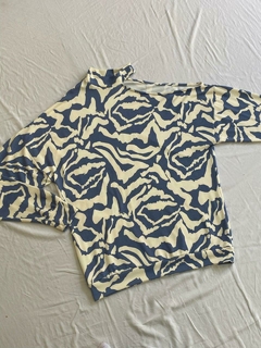 BUZO CON ABERTURA EN UN HOMBRO *LANILLA ESTAMPADA*