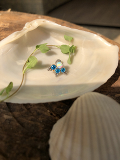 Piercing de titânio adornado com uma opala branca e três zircônias azuis (orelha) - comprar online