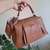 Bolsa maleta de mão ou transversal com acabamento em couro sintético e lenço decorativo.