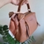 Bolsa Maleta de Mão ou Transversal REF751 com laço decorativo listrado, em tom caramelo, segurada por uma mão.