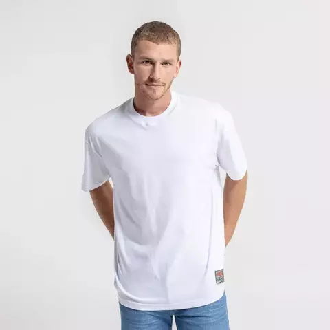 Remera Rusty Essential color blanco lisa, calce oversize fit, vista frontal completa en modelo masculino con jeans celestes y cuello redondo