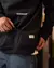 Buzo negro de la marca Cuerdos, con diseño canguro y logo visible en el pecho.