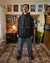 Hombre vistiendo un buzo negro de la marca Cuerdos, en un ambiente decorado con posters y muebles retro.