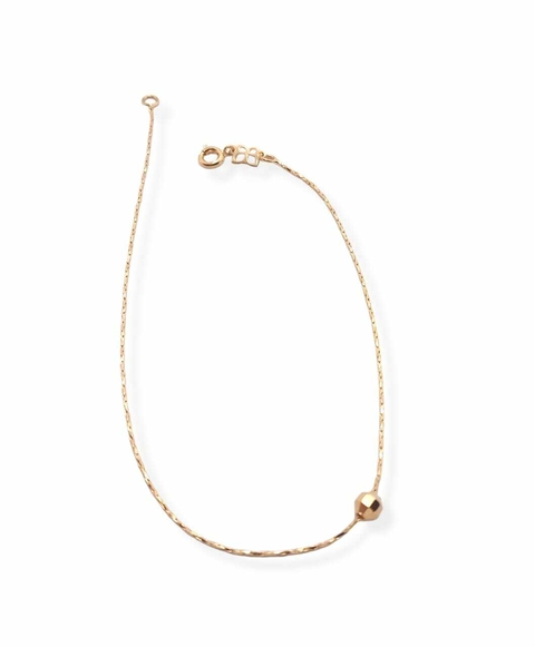 Tobillera laminada en oro 18k con dije esfera.