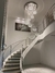 Escada elegante com lustre de cristal suspenso, criando um ambiente sofisticado e iluminado.