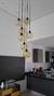 Lustre pendente com seis globos âmbar em uma cozinha moderna.