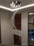 Um lustre de cristal em formato espiral, pendurado no teto, iluminando o ambiente com luzes LED.
