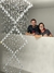 Casal sorrindo atrás de um lustre de cristal da Linha Cristal Zafira Quadrado.