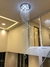 Um lustre moderno da Linha Cristal Caracol, com iluminação LED e detalhes em cristal, pendurado em um ambiente elegante.