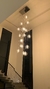 Iluminação suspensa moderna com lâmpadas de vidro transparente em um ambiente minimalista.