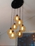 Lustre pendente com seis globos âmbar iluminados, detalhes em preto, suspenso no teto.