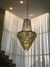 Um lustre elegante da Linha Cristal Imperial, pendurado em um ambiente com cortinas claras e iluminação suave.