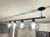 Lustre pendente Fiora com quatro globos de vidro transparente iluminados, fixado no teto com um suporte preto.