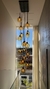 Um lustre moderno com globos de vidro âmbar pendurado em um corredor iluminado por luz natural.
