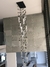 Lustre de vidro transparente da linha Dunáh, pendurado em um teto moderno, destacando-se sobre uma parede de concreto.