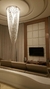 Lustre para pé direito duplo em formato de véu de noiva, com cristal, iluminando um ambiente moderno e elegante.