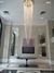 Lustre de cristal com design elegante, pendurado em um ambiente moderno, destacando-se sobre uma mesa preta.