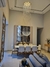 Iluminação elegante com lustre de cristal em uma sala de jantar moderna, destacando mesas e cadeiras.