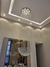 Um lustre de cristal em formato de bola dupla, pendurado no teto, refletindo luz em um ambiente moderno e sofisticado.