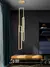 Iluminação pendente da linha Mirror de LED dourado em ambiente moderno.
