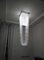 Um lustre elegante da Linha Cristal Paladino, no formato de véu de noiva, pendurado no teto de uma sala moderna.