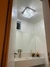 Lustre plafon quadrado transparente da Linha Cristal Harion, com acabamento brilhante e detalhes em cristal em um abenheiro.