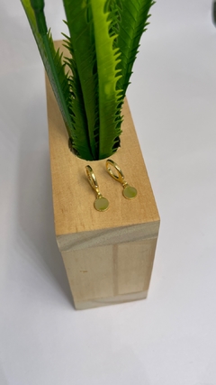 Argola com pingente de medalha.