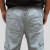 Calça cargo plus size jeans delave vista traseira, mostrando os bolsos e o elástico na cintura.