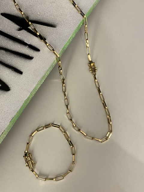 CONJUNTO CORRENTE E PULSEIRA CARTIE ELO ALONGADO FECHO TRAVA DUPLA (4,5mm) + PINGENTE CRUZ AMARRADA DE PRESENTE - BANHADO A OURO 18k