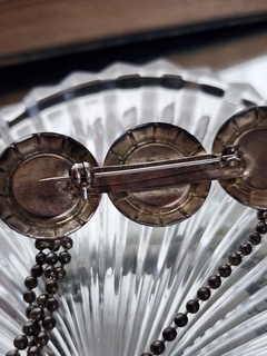 Prendedor con cadenas y perlas en internet