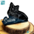 Placa decorativa com a silhueta de um gato preto e o nome "Salém" em destaque, apoiada em uma superfície de madeira.